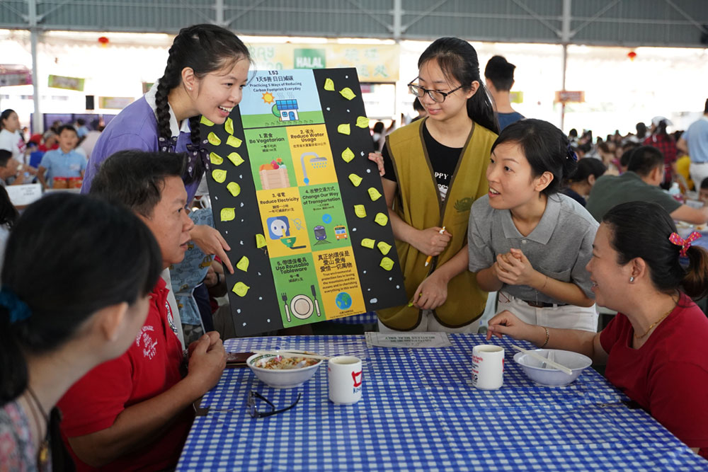 慈青拿着环保看板向会众宣导环保。摄 / 颜明德